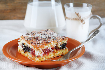 Homemade pie with jam and glass and jug of milk