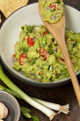 Guacamole with green onions and nachos. Selective focus.