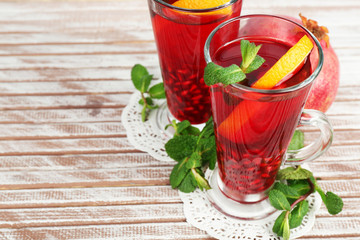 Pomegranate drink in glasses with mint and slices of orange