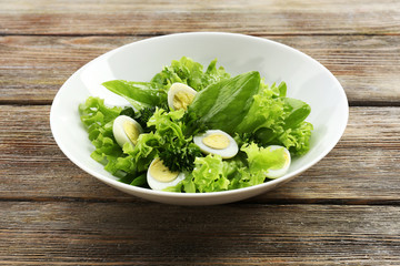 Salad with quail egg and basil in plate