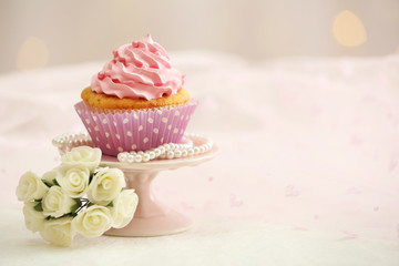 Sweet cupcake on table on light background