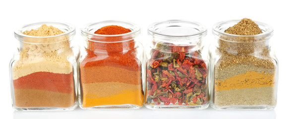 Different kinds of spices in glass bottle isolated on white