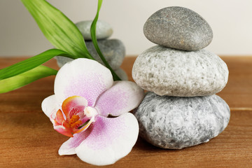 Fototapeta na wymiar Spa stones with orchid on table on light background