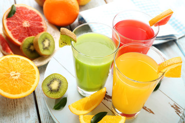 Fresh juices with fruits on wooden table
