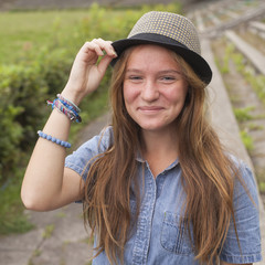 Cute teen girl wearing a hat, in the park (square series)