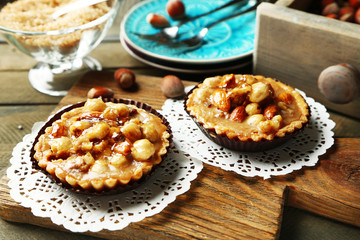 Mini cakes with nuts on wooden background