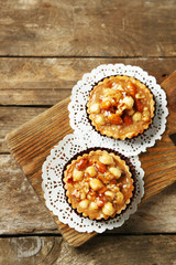 Mini cakes with nuts on wooden background