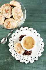 Cup of coffee and tasty cookie on color wooden background
