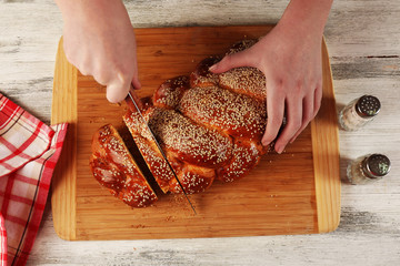 Cutting bun on wooden board on table close up