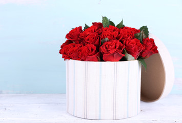 Bouquet of red roses in textile box on wooden background