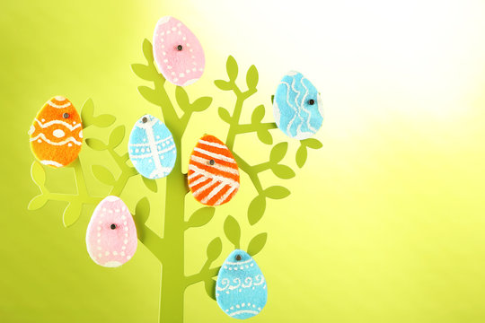 Felt Easter eggs on decorative tree  on colorful background