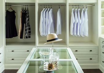 Fototapeta na wymiar white hat and jewelry set on a dresser table in a walk in closet