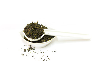 green tea leaves on spoon isolated on white background