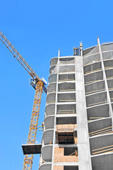 Naklejka premium Crane and building construction site against blue sky
