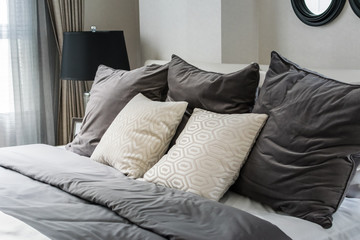 white and grey pillows on bed in modern bedroom