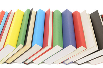 Leaning row line of colorful books isolated white background photo