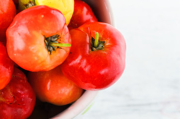 Cherries in cup on wooden table.