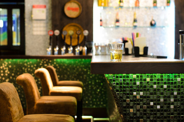 Empty bar with a tumbler of whiskey on the counter