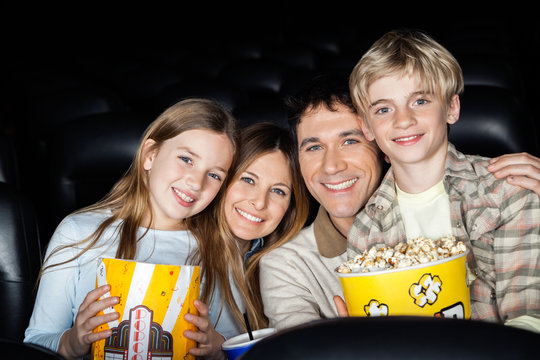 Happy Family With Popcorn At Cinema Theater