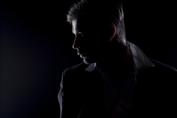 Fototapeta na wymiar Men's silhouette in the dark looking at side