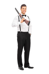 Obraz premium Elegant guy holding a shotgun over his shoulder