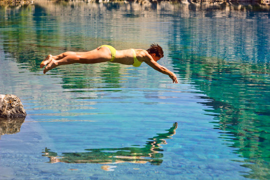girl diving in deep blue lake