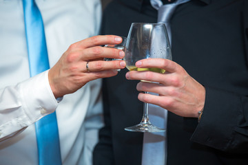 Elegant men in a business suit, holding glass of wine,