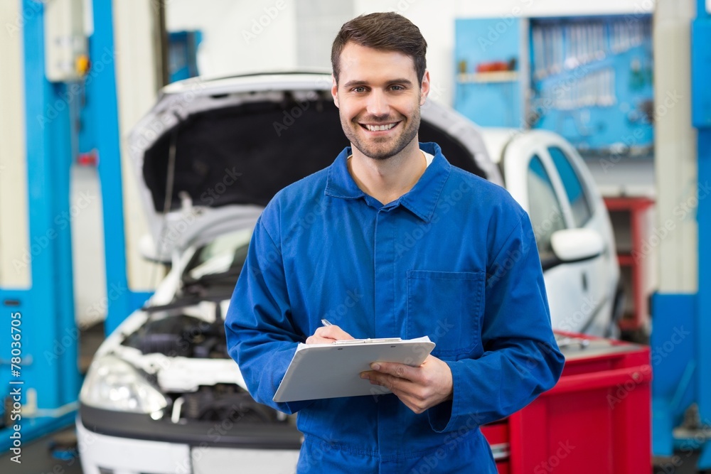 Poster smiling mechanic looking at camera