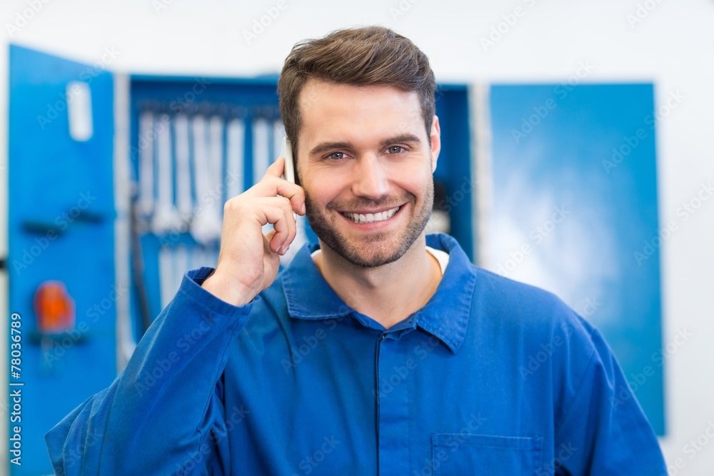 Poster smiling mechanic on the phone