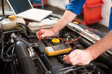 Mechanic using diagnostic tool on engine