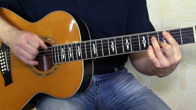 performer playing on the acoustic guitar