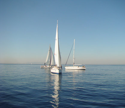 Fototapeta three yachts on a calm sea surface