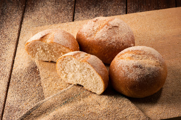 Freshly baked sliced buns on wooden board