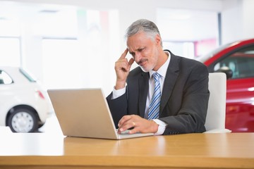 Naklejka premium Zdenerwowany biznesmen pracuje na komputerze