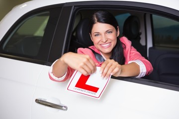 Cheerful female driver tearing up her L sign