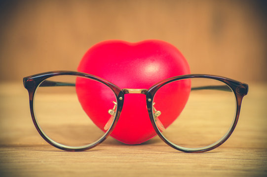 Heart of love wearing glasses on wooden