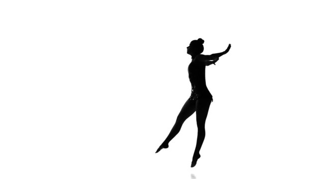Silhouettes Beautiful young acrobat performs jumps slow motion