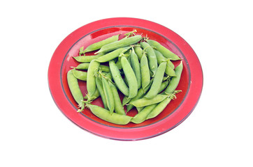 fresh sweet vegetable pea pods in red ceramic plate