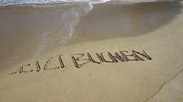Text jetzt buchen in Sand gemalt wird von Wellen weggesp&uuml;lt