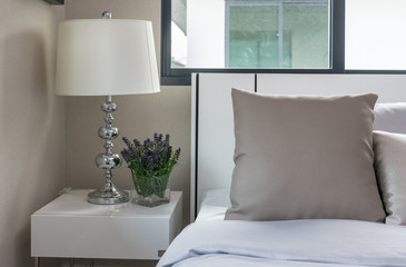 bedside lamp and plants in vase in bedroom