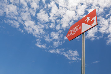 Tsunami warning orange sign on blue sky background