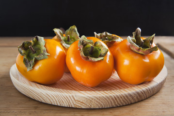 Fresh ripe persimmon on a wooden table