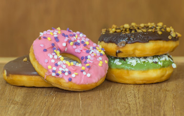 various glazed donuts isolate on wooden background.