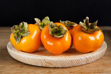 Fresh ripe persimmon on a wooden table