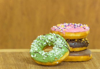 various glazed donuts isolate on wooden background.