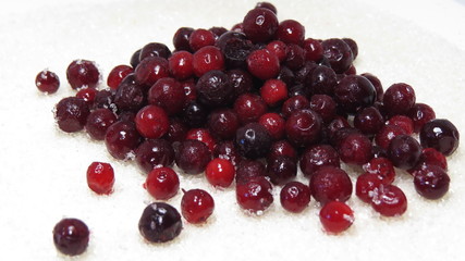 Frozen cranberries scattered on sugar