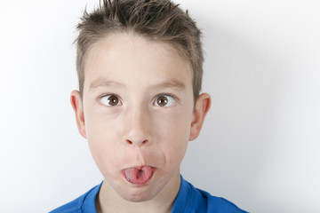 cute boy making funny face, isolated on white background. Studio