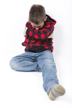 A Sad Young Boy Sit On White Background