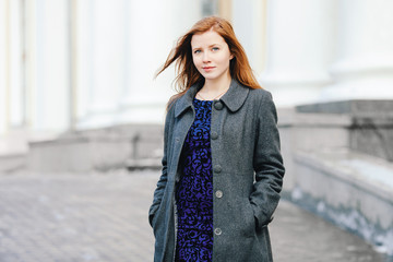 Portrait of young beautiful redhead woman at winter outdoors