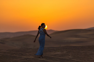 girl in the desert on a background of a sunset